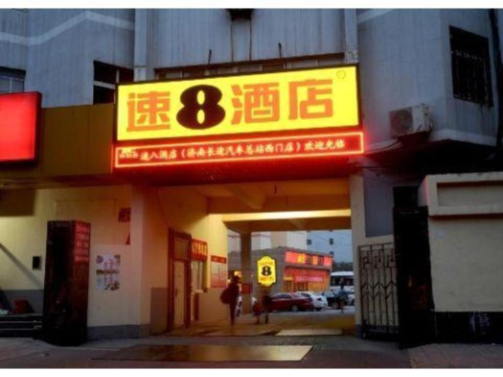 um posto de gasolina com um sinal na frente dele em Super 8 Hotel Jinan West Gate of Long Distance Bus Station em Beiyuan