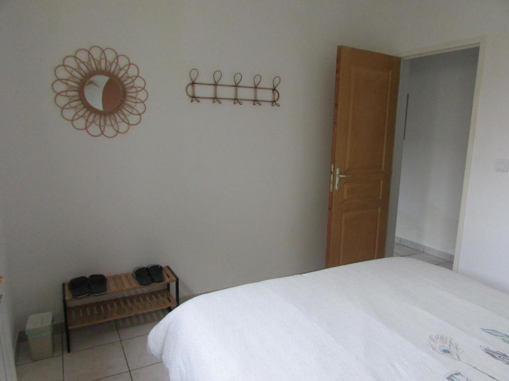 1 dormitorio con cama y espejo en la pared en Chambre agréable dans une maison avec un grand lit, en Nimes