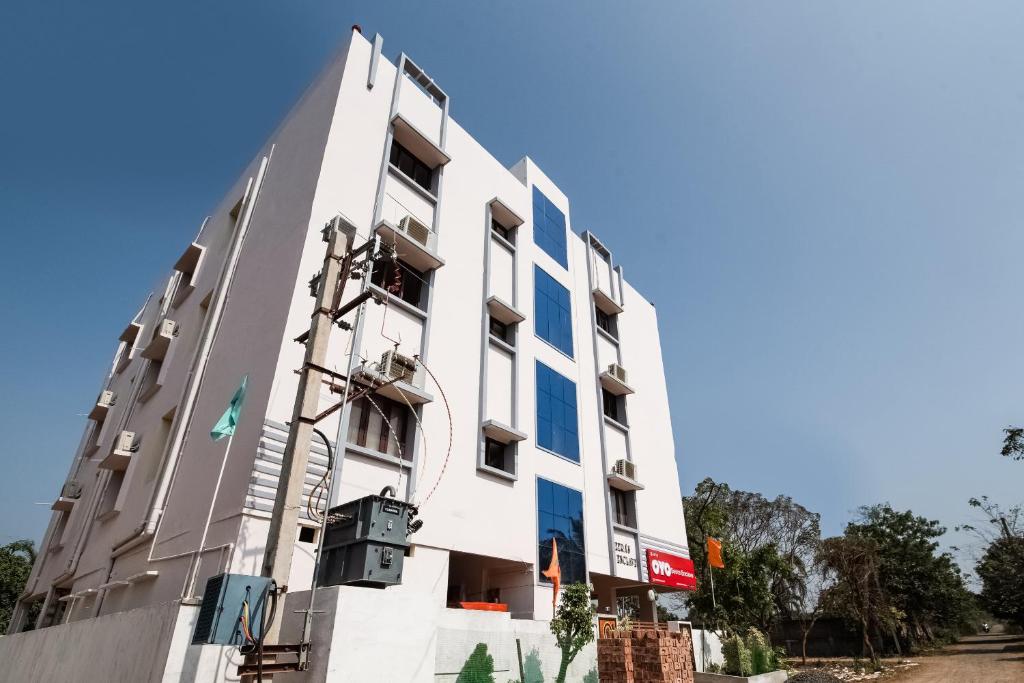 a white building with blue windows at OYO Seera Enclave in Rājahmundry