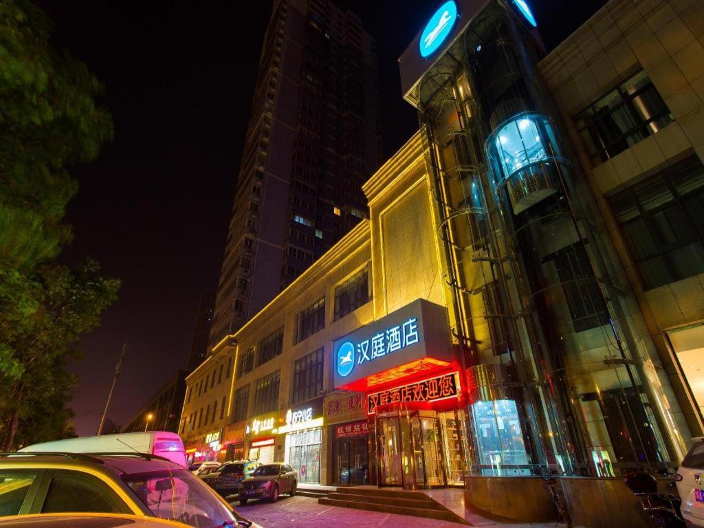 ein Gebäude mit einem Schild an der Straßenseite in der Unterkunft Hanting Hotel Xian Changqing Road Metro Station in Xi'an