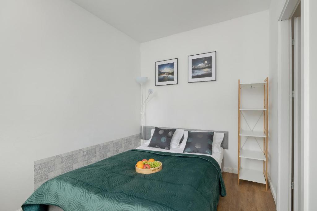 ein Schlafzimmer mit einem Bett mit einer Obstschale darauf in der Unterkunft Unique Apartments in Szczecin by Rent like home in Stettin