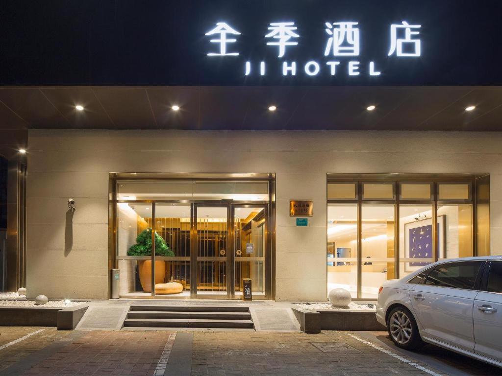un hotel con una macchina parcheggiata di fronte di Ji Hotel Shanghai Wuwei Dong Road Metro Station a Shanghai