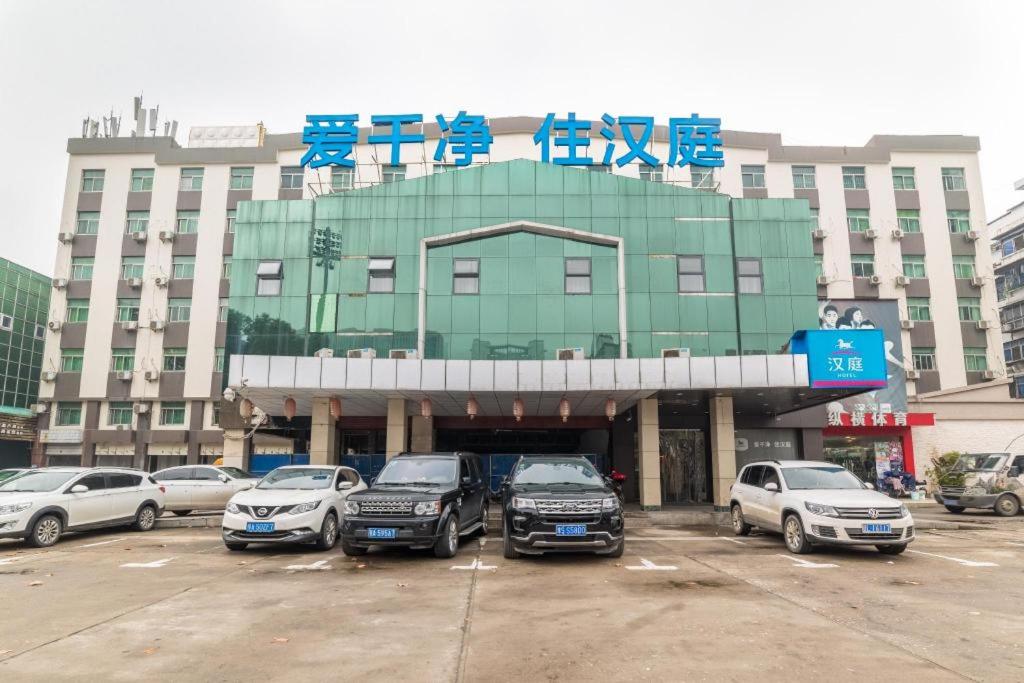 um grande edifício com carros estacionados num parque de estacionamento em Hanting Hotel Wuhan Xinhua Road Xiehe Hospital em Wuhan