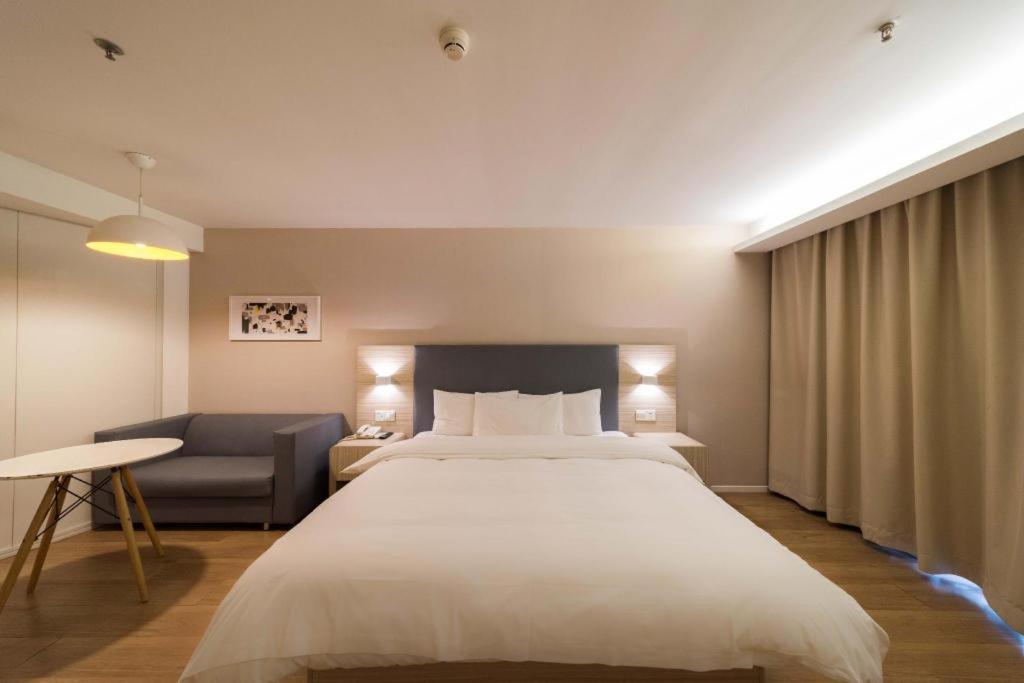 Hanting Hotel Wuhan Hankou Railway Metro Station tesisinde bir odada yatak veya yataklar