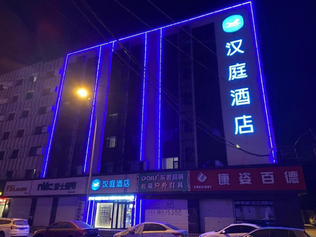 un edificio con luces azules en el lateral. en Hanting Hotel Changchun Chongqing Road Vivid City en Changchún