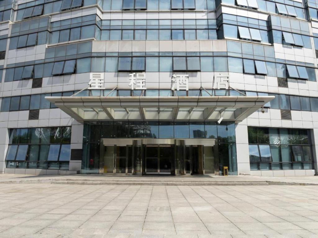 ein großes Glasgebäude mit einem großen Eingang in der Unterkunft Starway Hotel Ha'Erbin Convention And Exhibition Center in Harbin