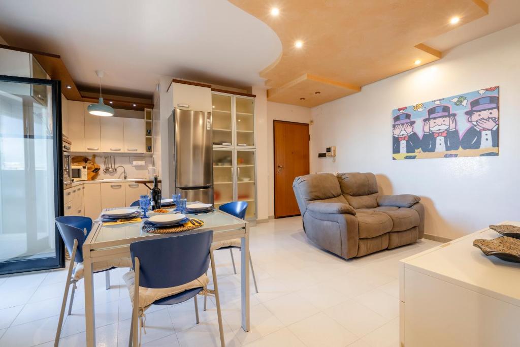 a kitchen and living room with a table and chairs at Dimora Verdi Joyful Apartment in Monopoli