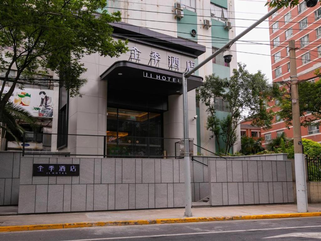 un edificio con un cartello sul lato di una strada di Ji Hotel Shanghai Changshou Road Shaanxi North Road a Shanghai