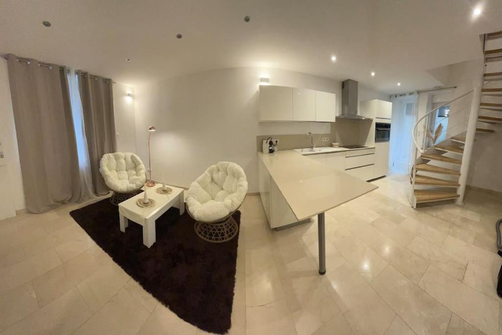 un salon avec une table et des chaises et une cuisine dans l'établissement Joli Appartement, à Épinal