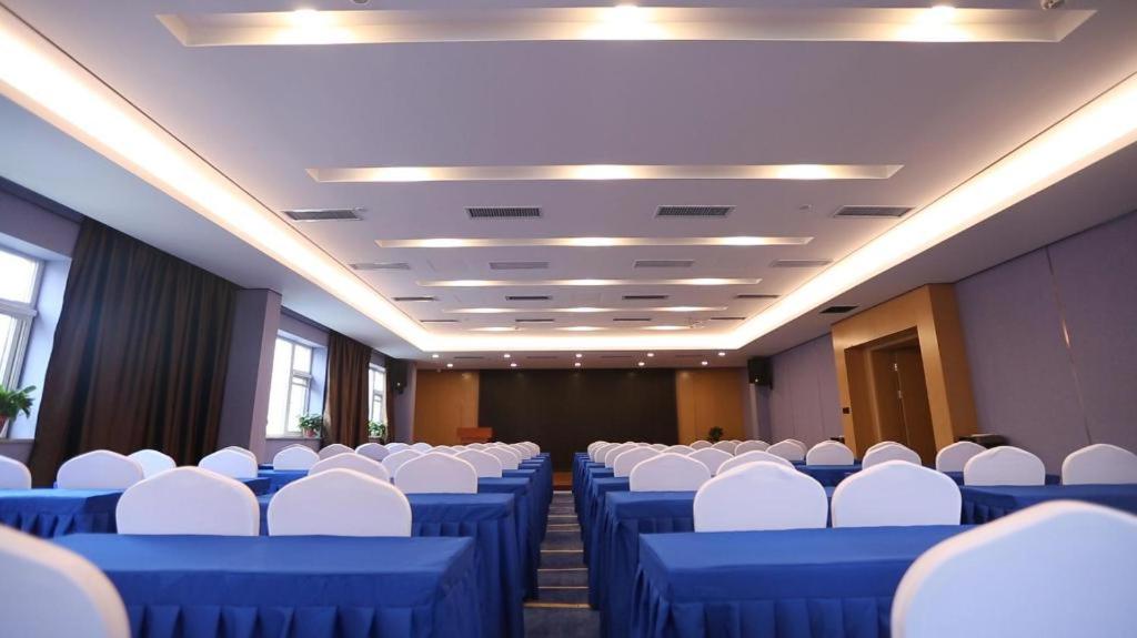 ein Konferenzraum mit blauen Tischen und weißen Stühlen in der Unterkunft Starway Hotel Zhengzhou Jingguang Road Metro Station in Zhengzhou