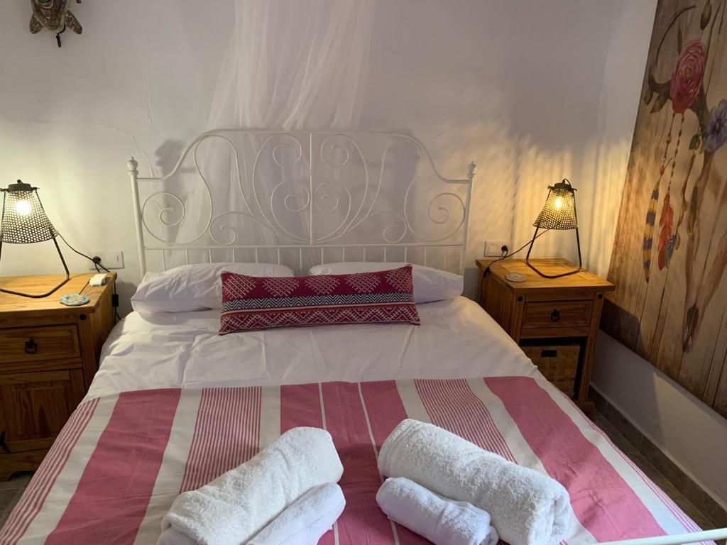 1 dormitorio con 1 cama blanca, 2 mesitas de noche y 2 lámparas en Casa Meraki, en Bédar