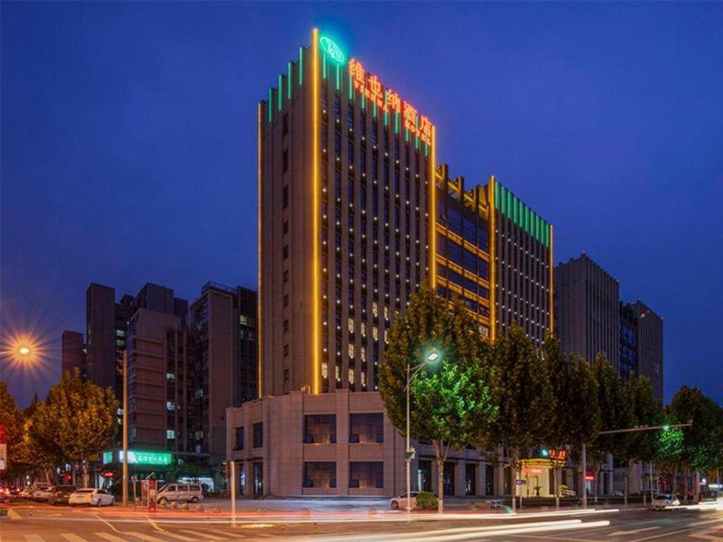 Un grand bâtiment avec des lumières au-dessus dans l'établissement Vienna Hotel Zhengzhou Only Henan Movie Town, à Zhongmou