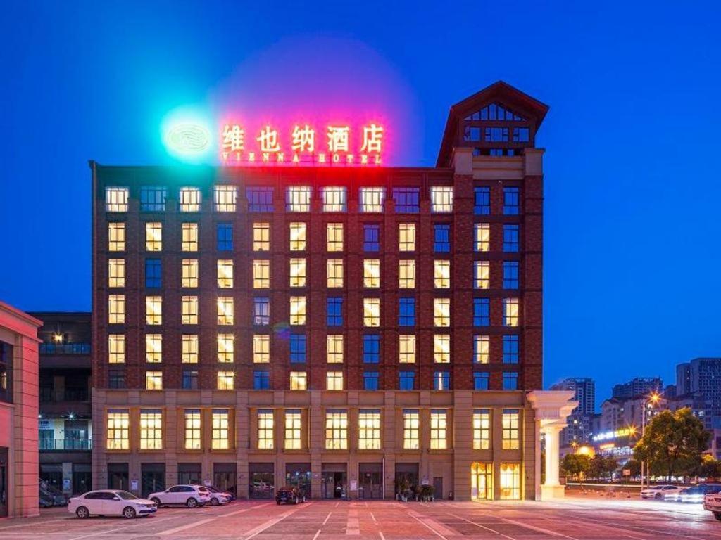 a building with a sign on top of it at night at Vienna Hotel Chongqing Jiangjin Shuangfu in Zouma