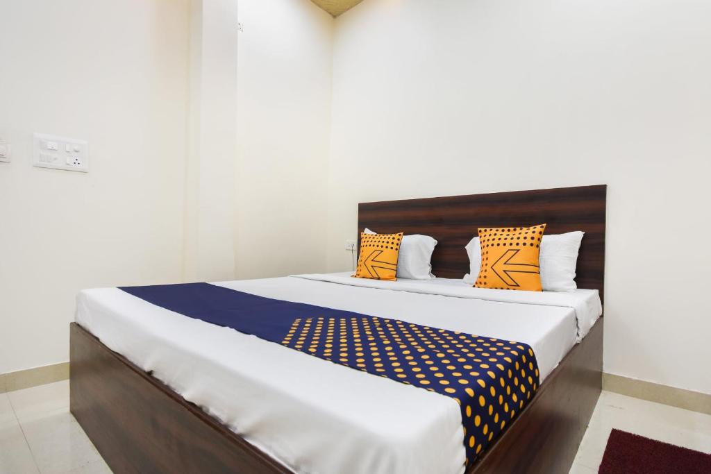 een slaapkamer met een groot bed met oranje en blauwe kussens bij SPOT ON Deep Guest House in Amritsar