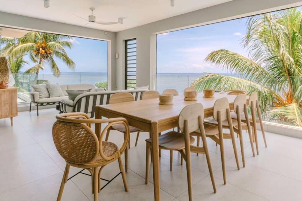 uma sala de jantar com mesa e cadeiras e o oceano em Tamarin Sunset Beach IV em Tamarin