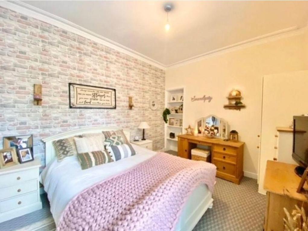 a bedroom with a bed and a brick wall at Entire, main door, pet friendly, home away from home, East Ayrshire in Newmilns