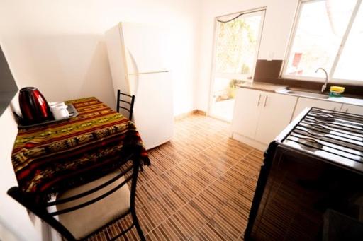 uma cozinha com uma mesa com cadeiras e um fogão em Tourist house 1 em Otavalo