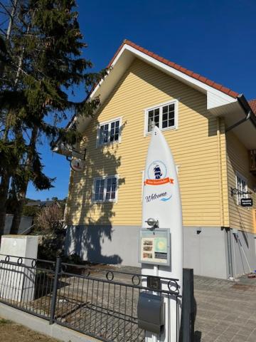 a parking meter in front of a yellow house at Haus Stoertebeker Appartements - Hotel Garni, Seebad Lubmin in Lubmin