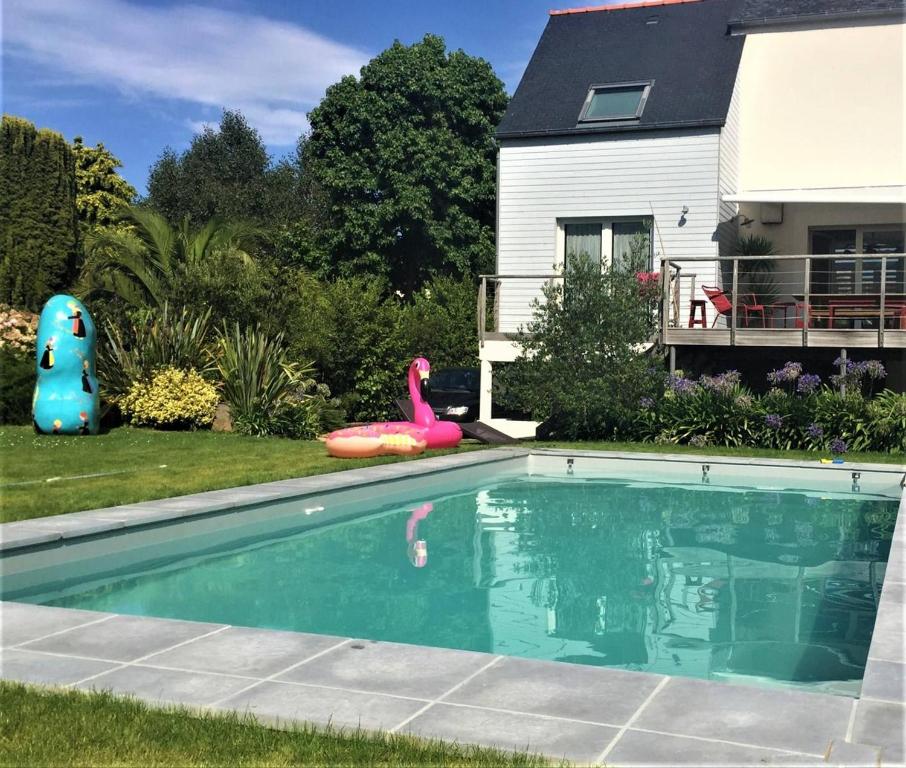 a swimming pool with a pink flamingo and a house at Superbe maison 4 étoiles pour 8 pers avec piscine sur le port de PERROS-GUIREC - Réf 873 in Perros-Guirec