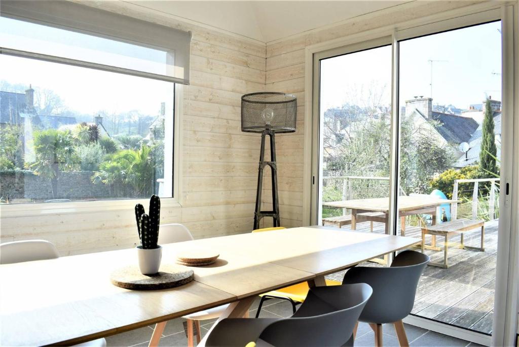 a dining room with a table and chairs and a large window at Superbe maison 4 étoiles pour 8 pers avec piscine sur le port de PERROS-GUIREC - Réf 873 in Perros-Guirec