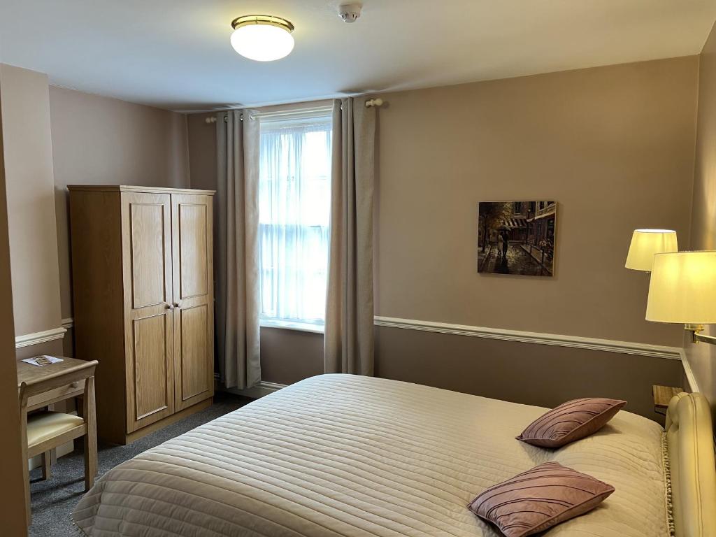sypialnia z łóżkiem i oknem w obiekcie Royal Oak Hotel, Garstang w mieście Garstang