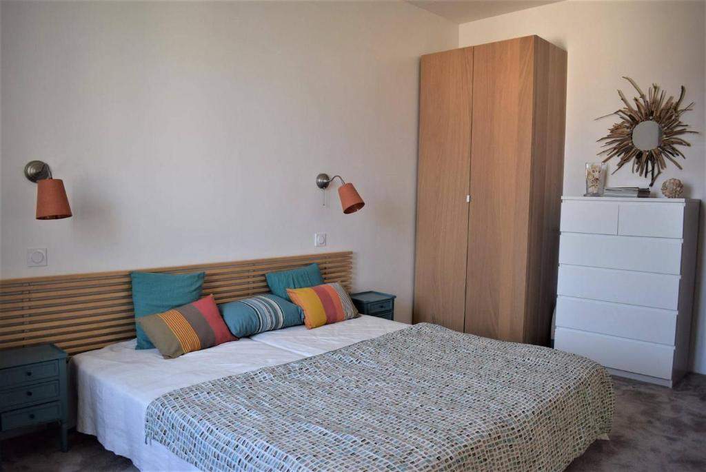 a bedroom with a bed with a wooden headboard at Superbe maison 4 étoiles pour 8 pers avec piscine sur le port de PERROS-GUIREC - Réf 873 in Perros-Guirec