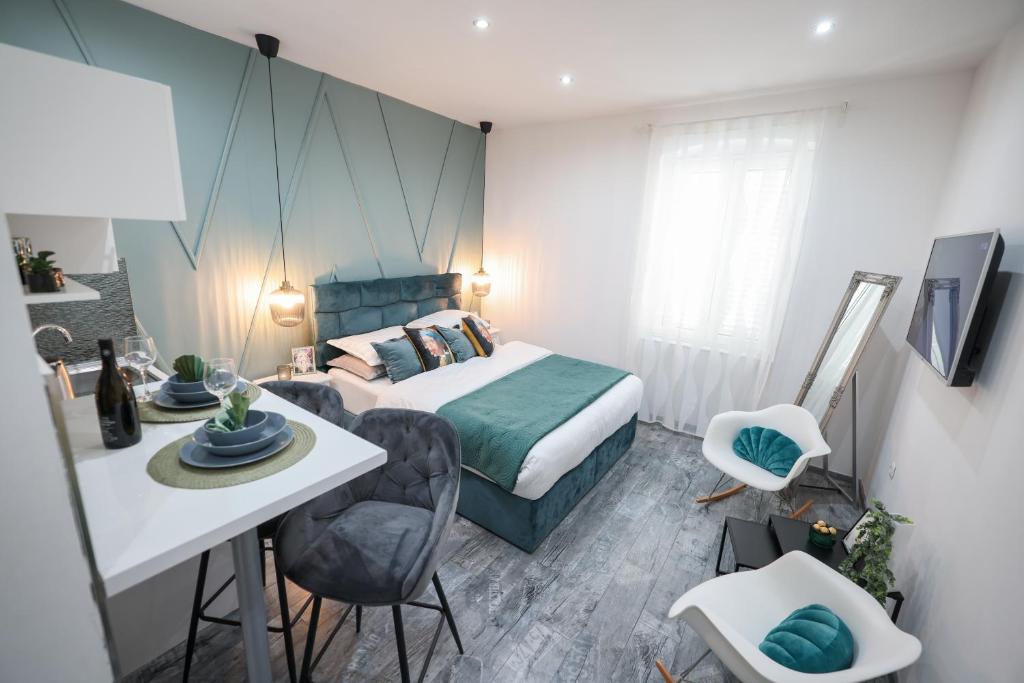 1 dormitorio con 1 cama, mesa y sillas en Apartments Blue Ivy, en Zadar