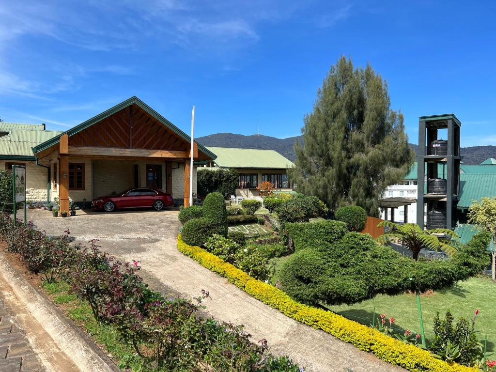 ein Haus mit Garten davor in der Unterkunft Tea Bush Hotel in Nuwara Eliya