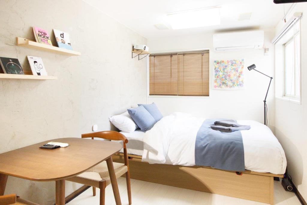 a small bedroom with a bed and a table at Kaku Studio Apartment Ikebukuro in Tokyo
