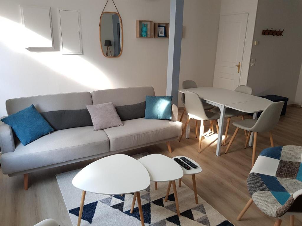 ein Wohnzimmer mit einem Sofa und einem Tisch in der Unterkunft La récréation Lochoise in Loches