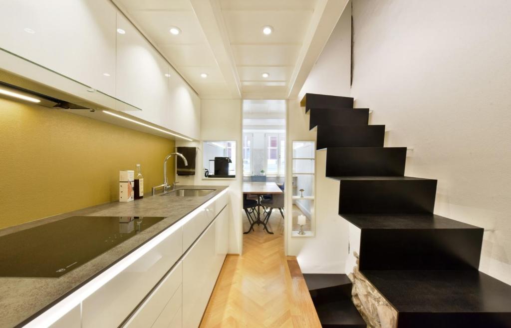eine Küche mit einer schwarz-weißen Treppe und einem Tisch in der Unterkunft Boutique City Design Bijou - an bester Lage in Thun