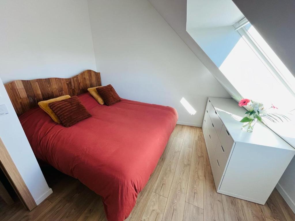 - une chambre avec un lit rouge et une armoire blanche dans l'établissement - Happy Home -, à Lovagny