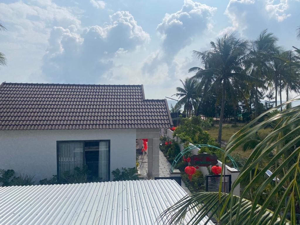 Biały dom z palmą przed nim w obiekcie Bốn Mùa homestay w mieście Phu Yen