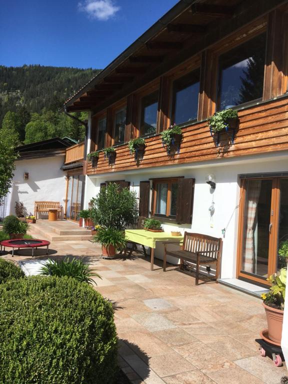 eine Terrasse eines Hauses mit Bänken und Pflanzen in der Unterkunft Landhaus Renata - Wendelstein in Bayrischzell