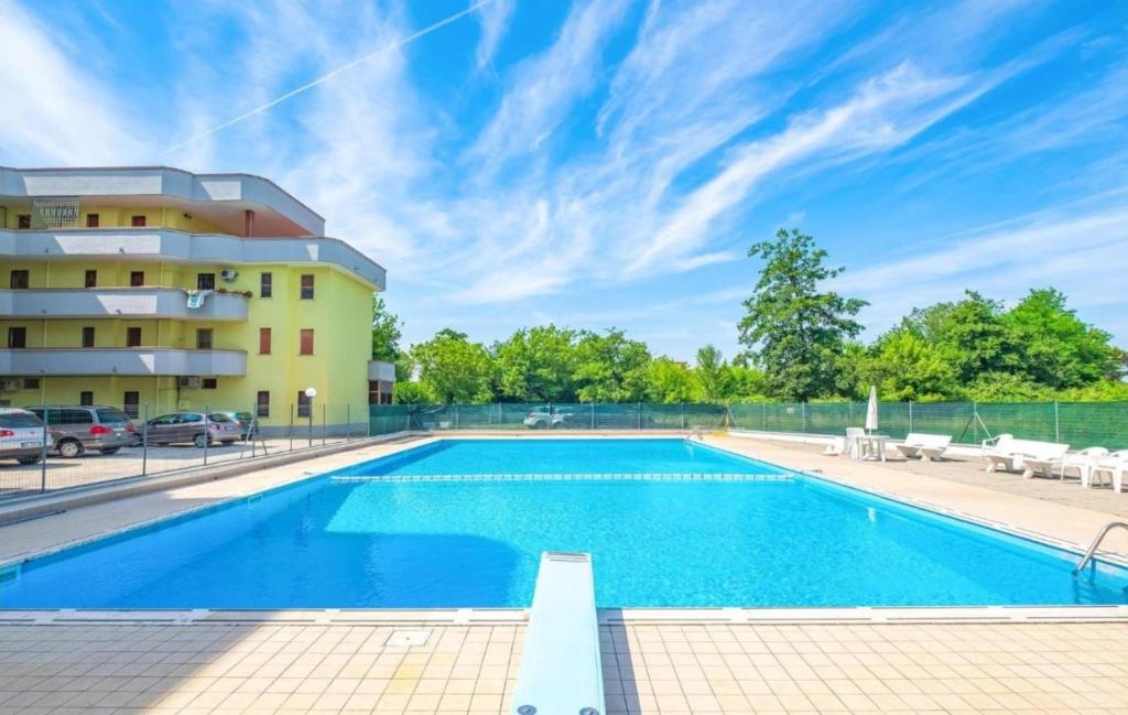 a swimming pool in front of a building at La Dolce Vita - Apartment with shared pool and large terrace in Lido delle Nazioni