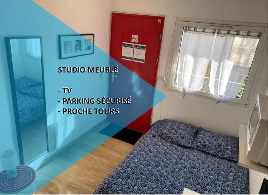 シャンブレー・レ・トゥールにあるStudio aménagé + parkingのベッドと赤いドアが備わる小さな部屋です。