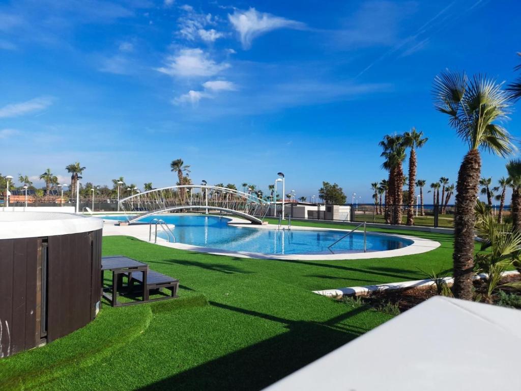 una piscina con un tobogán en un parque con palmeras en AyF MODERNO Y LUJOSO EN 1ª LÍNEA DE PLAYA, en Oropesa del Mar