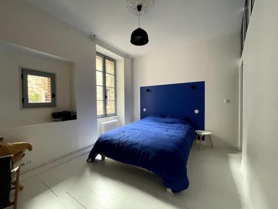 - une chambre blanche avec un lit bleu dans l'établissement Magnifique Appart - fameuse Rue piétonne MrJoffre, à Cahors