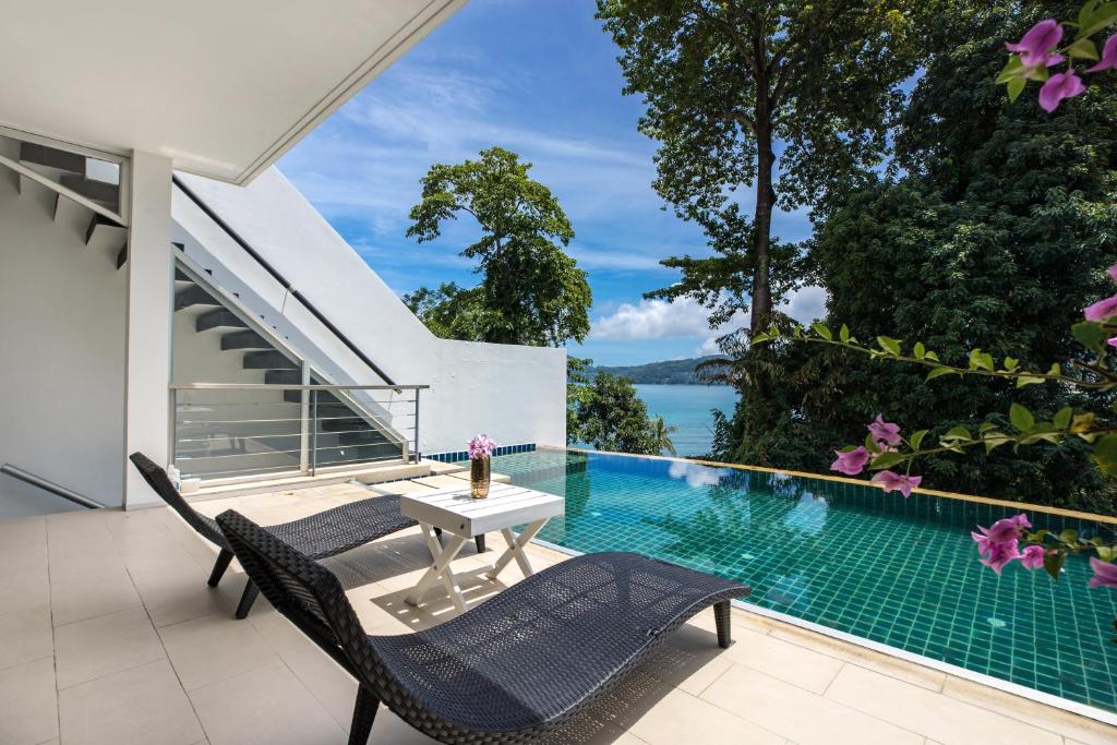 un patio con mesa y sillas junto a una piscina en Private 3-Storey Pool Villa Atika 10, for 7, views of Patong Bay en Patong