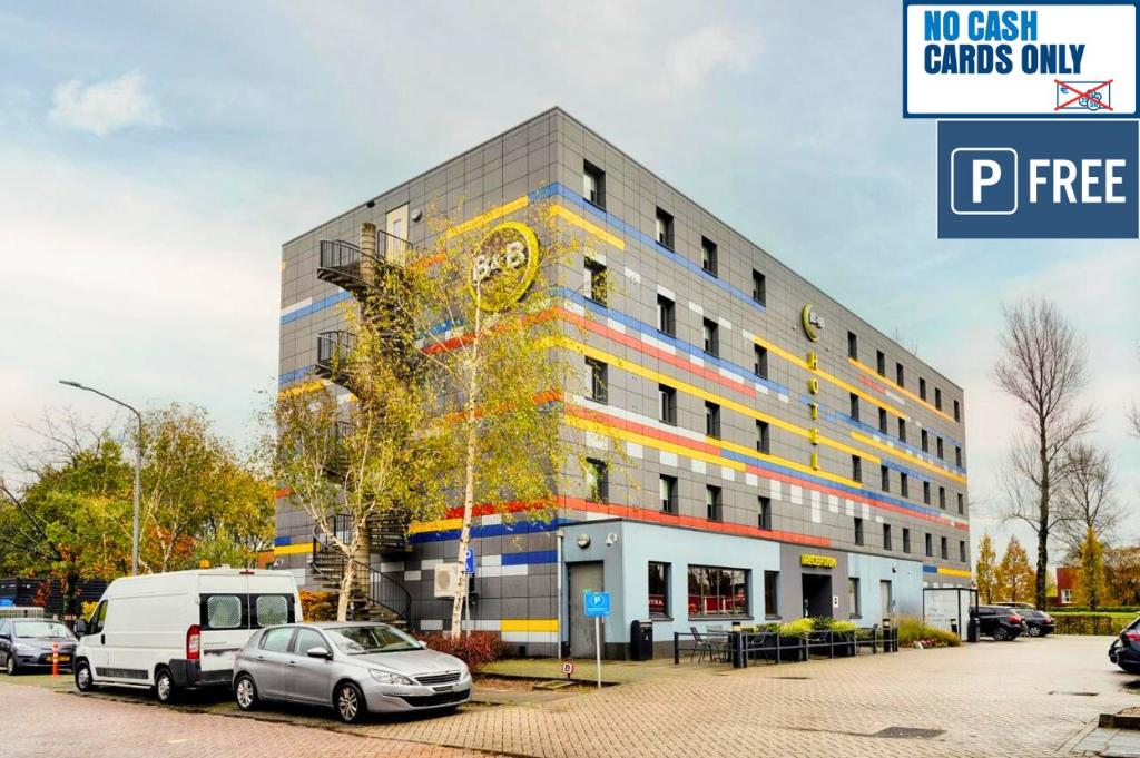 un edificio con coches estacionados frente a él en B&B Hotel Amsterdam-Zaandam, en Zaandam