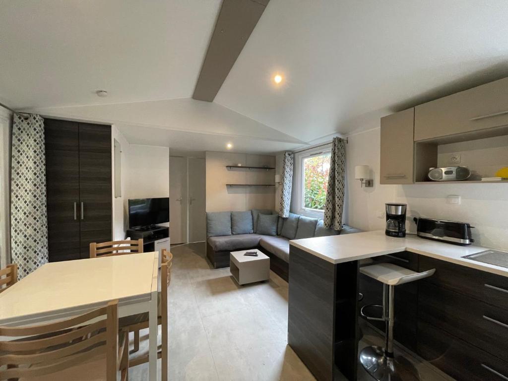 une cuisine et un salon avec un canapé dans l'établissement Superb Mobilhome Ba302 - 3 bedrooms Siblu Bonne Anse La Palmyre, aux Mathes