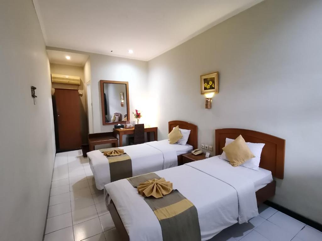 Postel nebo postele na pokoji v ubytování Hotel Catur Putra