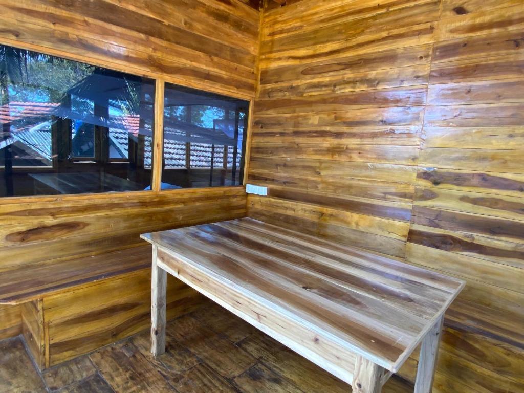 un banc en bois installé à l'intérieur d'une cabine dans l'établissement Surf Beach Hotel, à Baie d'Arugam