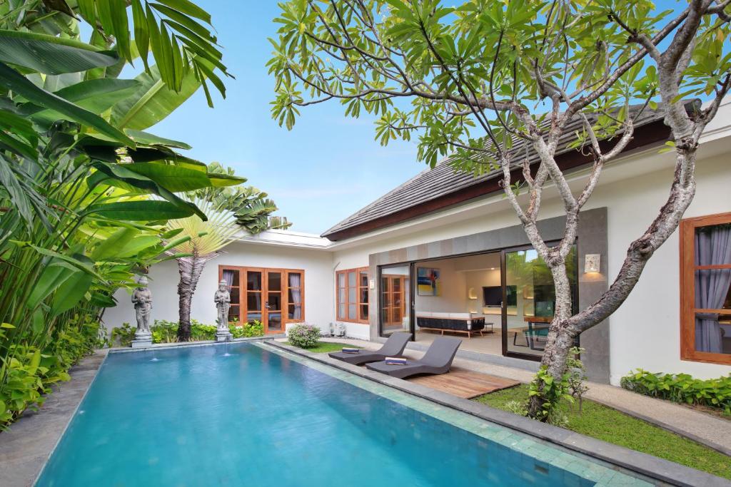 a swimming pool in the backyard of a villa at D'Sawah Villa Umalas in Canggu