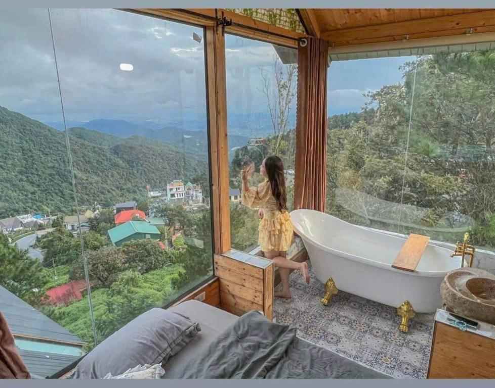 een meisje in een bad in een kamer met een raam bij mimosa villa tam dao in Tam Ðảo