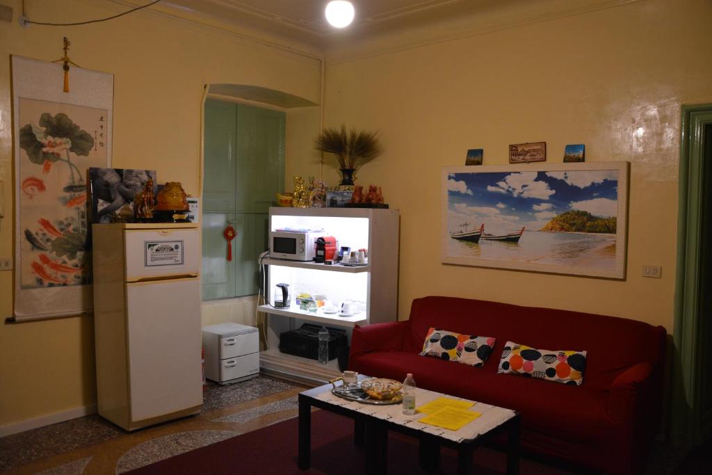 a living room with a red couch and a refrigerator at Green House in Genoa