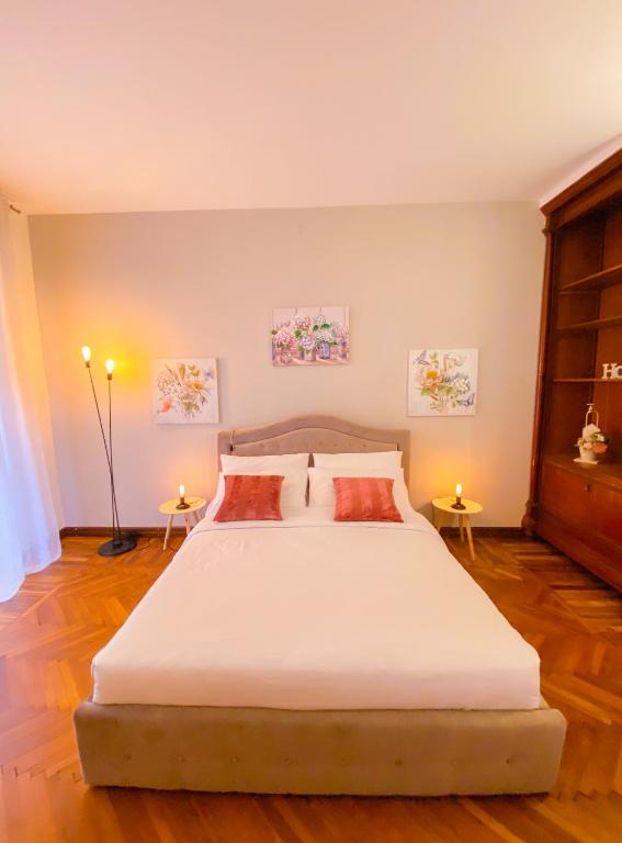 - une chambre avec un grand lit blanc et 2 tables dans l'établissement Arena Sweet Home in Verona, à Vérone