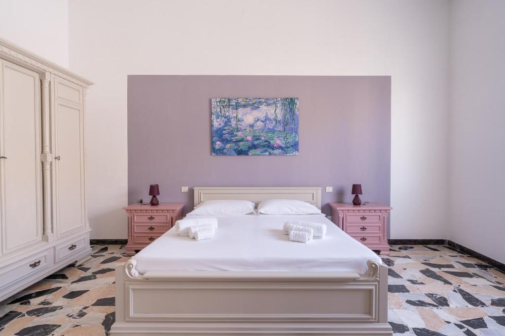 Un dormitorio con una cama blanca y un cuadro en la pared. en Spacious House in Sinis, en Cabras