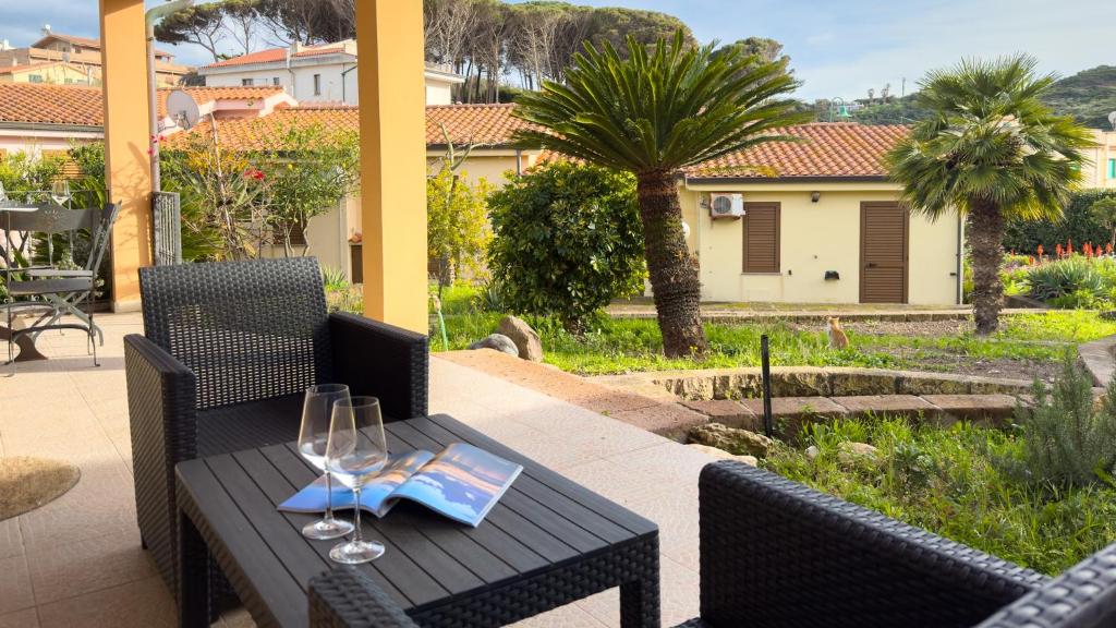 a table with two wine glasses and a book on it at Sardinianworld - La Casa Delle Rose in Santa Caterina