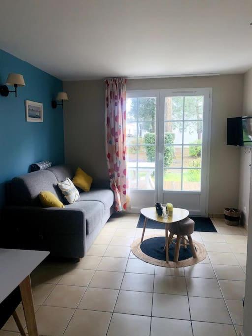 un salon avec un canapé et une table dans l'établissement Hélice - Maison sous les pins, à Longeville-sur-Mer